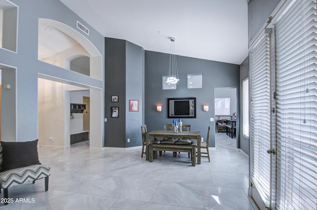 dining area with high vaulted ceiling