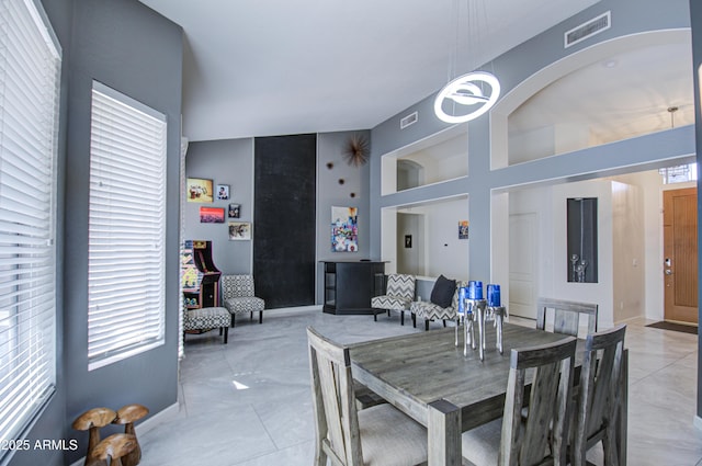 tiled dining space with a high ceiling