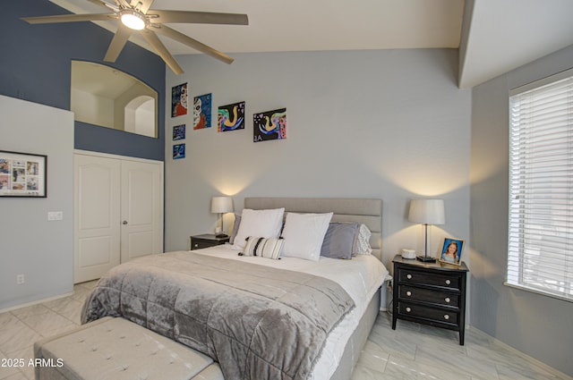 bedroom with lofted ceiling, a closet, and ceiling fan