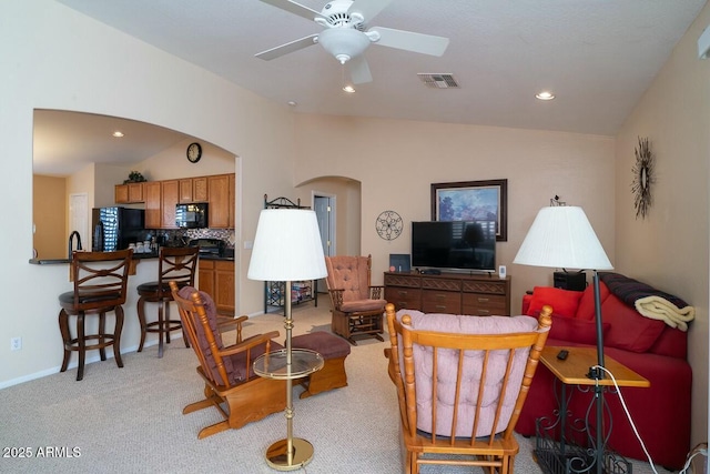 carpeted living room with vaulted ceiling and ceiling fan