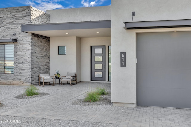 view of exterior entry with a garage and elevator