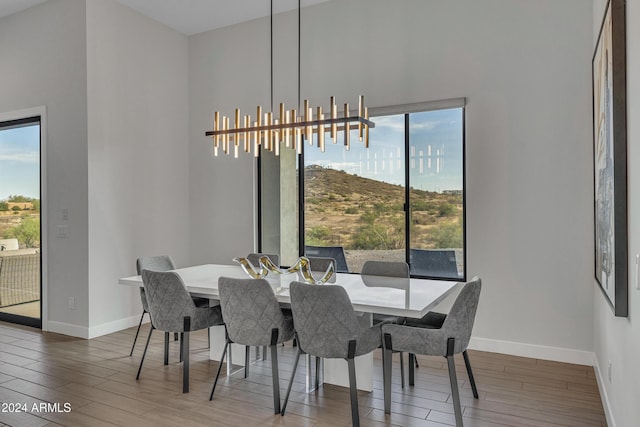 dining room featuring a chandelier, hardwood / wood-style floors, and a high ceiling