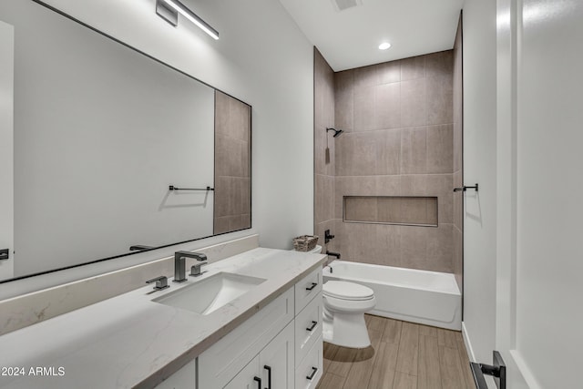 full bathroom with vanity, tiled shower / bath combo, and toilet