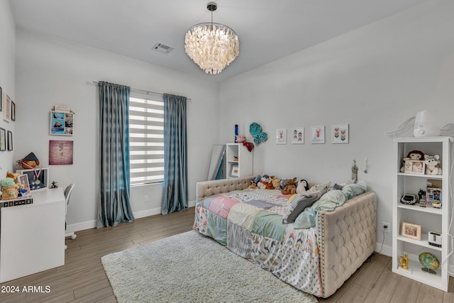 bedroom with a notable chandelier and light hardwood / wood-style floors