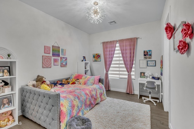 bedroom featuring wood-type flooring and an inviting chandelier