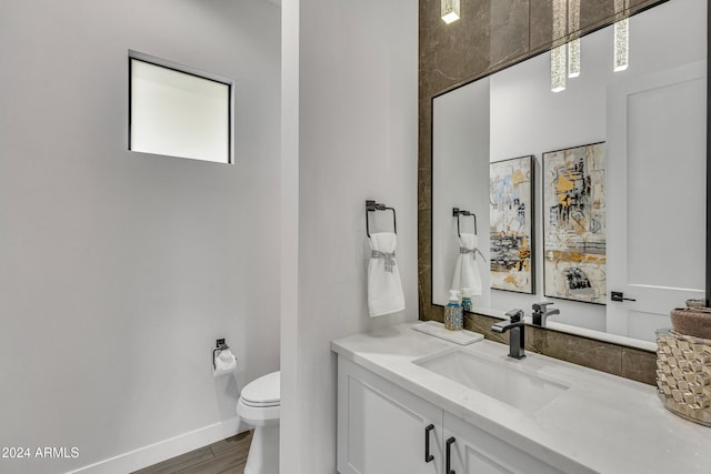 bathroom featuring hardwood / wood-style flooring, vanity, and toilet