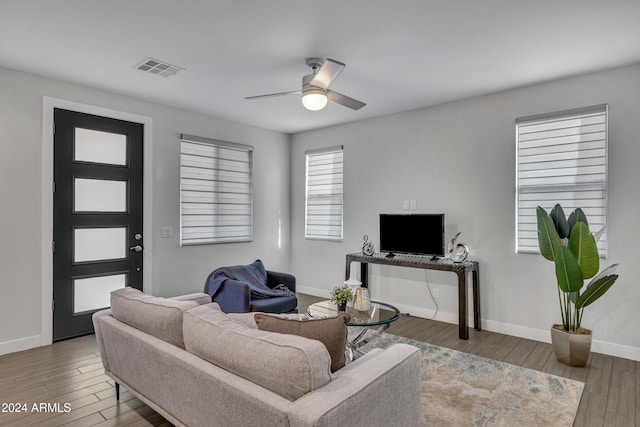 living room featuring ceiling fan and dark wood-type flooring