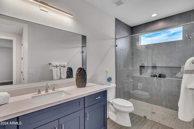 bathroom featuring wood-type flooring, vanity, toilet, and an enclosed shower