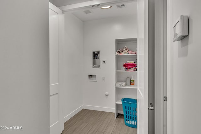 laundry room featuring hookup for a washing machine, light wood-type flooring, and hookup for an electric dryer