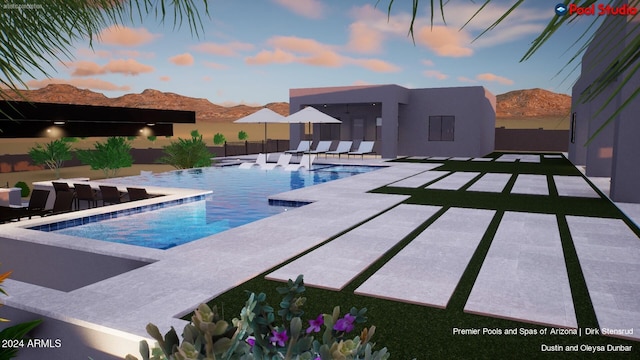 pool at dusk featuring a patio area and a mountain view