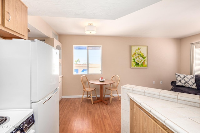 12221 W Bell Rd Unit 362, Surprise, AZ 85378 - kitchen with plenty of natural light, tile counters, freestanding refrigerator, and light wood finished floors