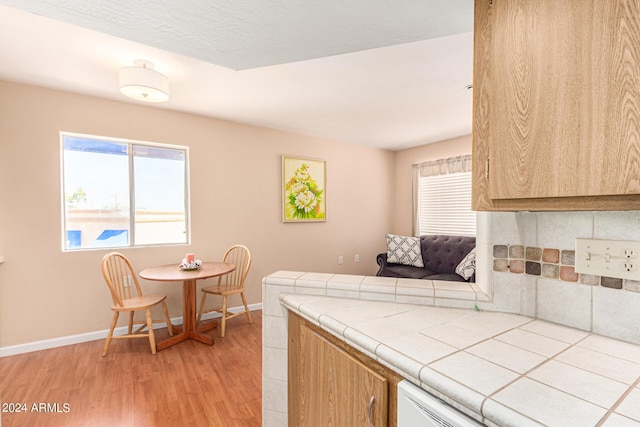 12221 W Bell Rd Unit 362, Surprise, AZ 85378 - kitchen featuring light wood-style floors, baseboards, plenty of natural light, and tile countertops