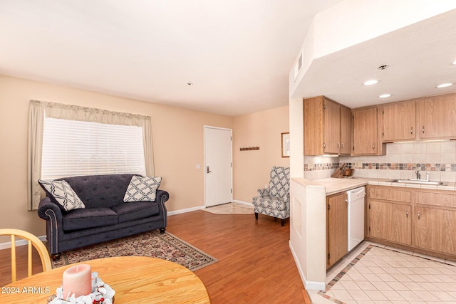 12221 W Bell Rd Unit 362, Surprise, AZ 85378 - kitchen featuring backsplash, white dishwasher, a sink, baseboards, and light wood-style flooring