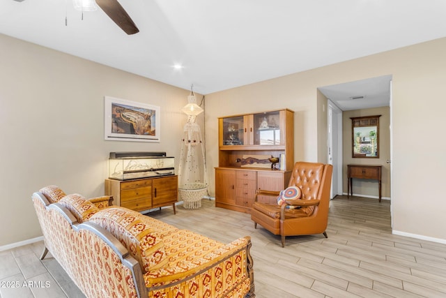 living room with ceiling fan and light hardwood / wood-style flooring