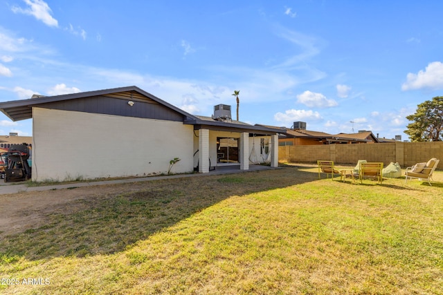 back of house featuring a lawn