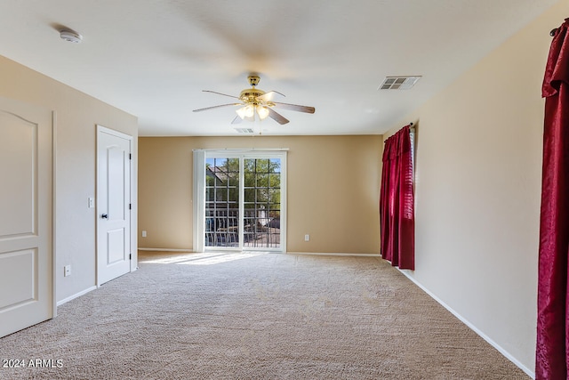 carpeted spare room with ceiling fan