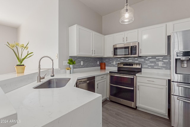 kitchen with sink, white cabinets, hanging light fixtures, and appliances with stainless steel finishes