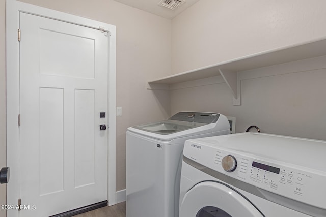 laundry area featuring dark hardwood / wood-style flooring and washing machine and dryer