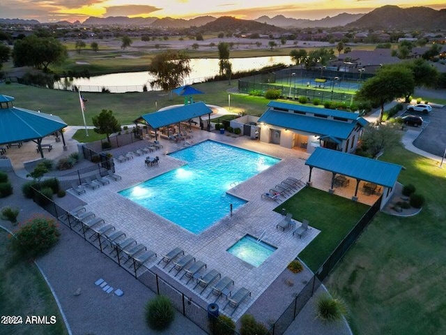 pool at dusk with a gazebo and a water view