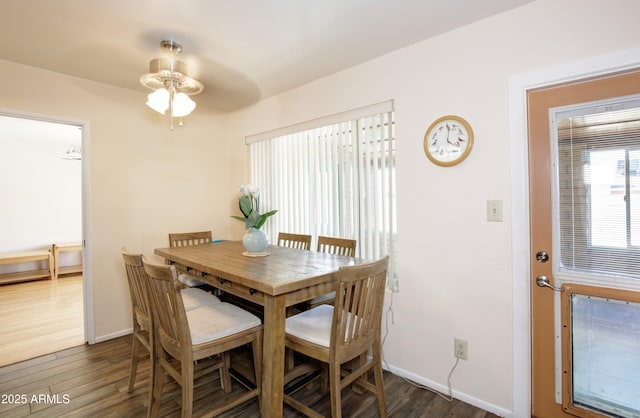 dining space featuring dark wood-type flooring and baseboards