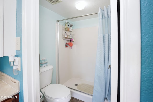 bathroom featuring visible vents, a shower stall, and toilet