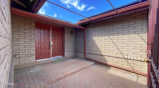 doorway to property featuring brick siding