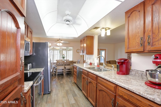 kitchen featuring ceiling fan, a sink, visible vents, appliances with stainless steel finishes, and brown cabinets