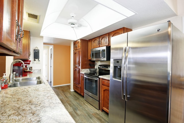 kitchen with light countertops, visible vents, appliances with stainless steel finishes, a sink, and wood finished floors