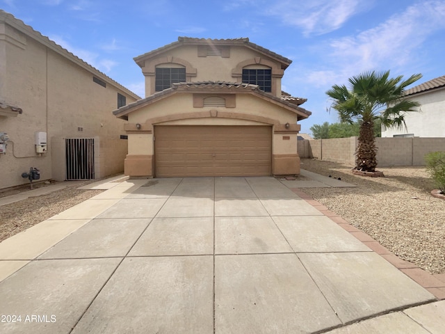 mediterranean / spanish home with fence, a garage, driveway, and stucco siding