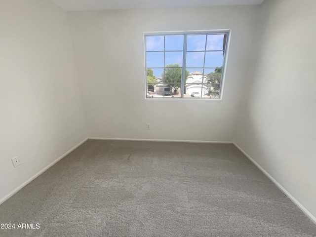 carpeted spare room featuring baseboards