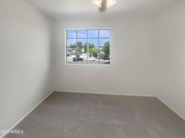 empty room featuring baseboards, carpet floors, and ceiling fan