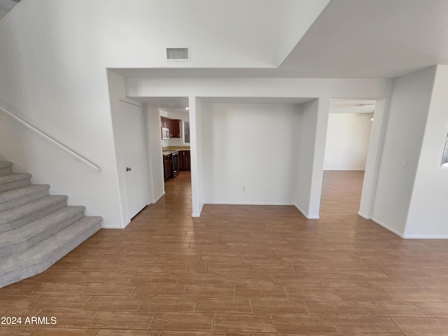 interior space featuring stairway, visible vents, baseboards, and wood finish floors