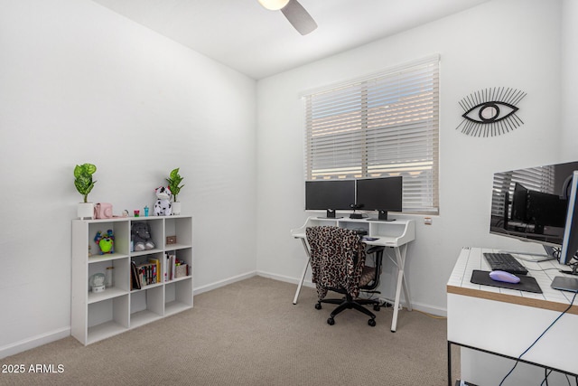carpeted office with a ceiling fan and baseboards