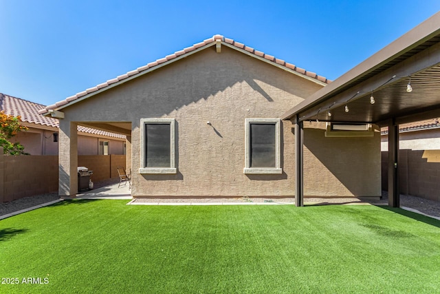 rear view of property featuring fence, a patio area, and stucco siding