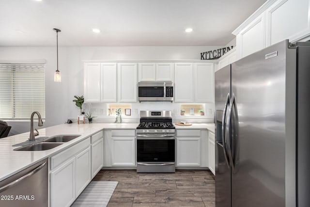 kitchen with light countertops, white cabinets, a sink, dark wood finished floors, and stainless steel appliances
