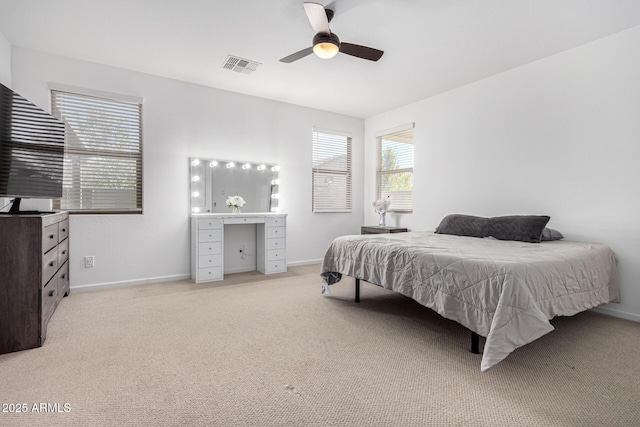 bedroom featuring light colored carpet, baseboards, visible vents, and a ceiling fan