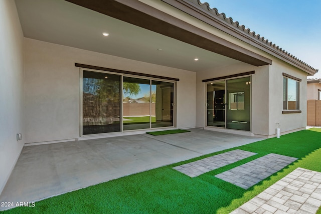 rear view of house featuring a patio and a lawn