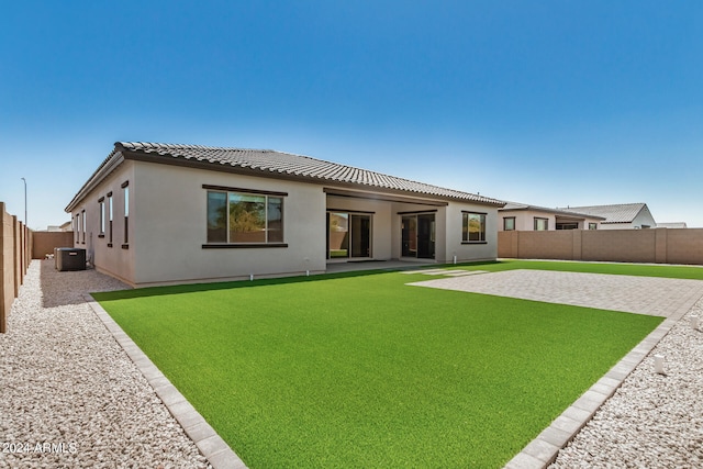 rear view of house with a patio area, central AC, and a lawn