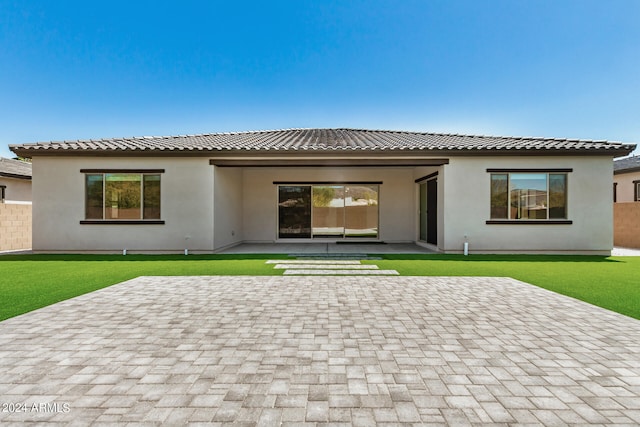 rear view of property featuring a patio and a lawn