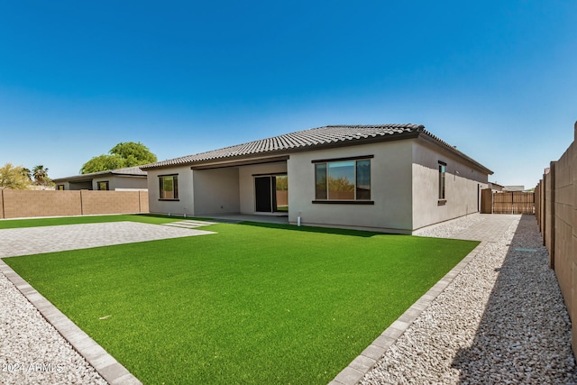 rear view of property featuring a yard and a patio