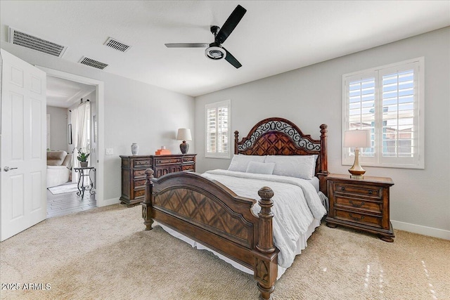 bedroom with light carpet, visible vents, and multiple windows