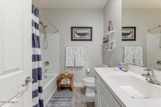 bathroom featuring vanity, toilet, shower / bath combo with shower curtain, and baseboards