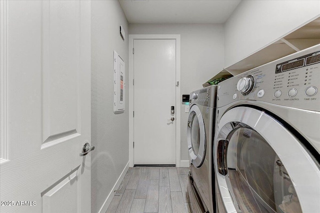 washroom with washer and dryer, baseboards, laundry area, and light wood finished floors