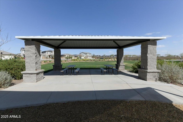 view of property's community featuring a gazebo, a lawn, and a patio