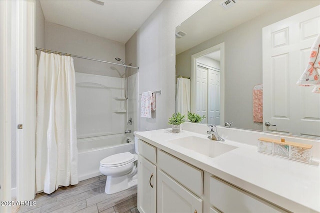 full bathroom featuring visible vents, shower / bathtub combination with curtain, toilet, wood finished floors, and vanity