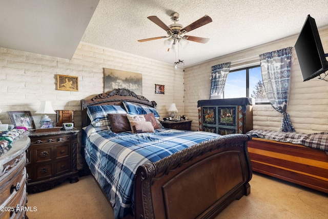 bedroom with ceiling fan, light colored carpet, and a textured ceiling