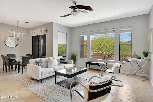 living area with baseboards, plenty of natural light, and ceiling fan with notable chandelier