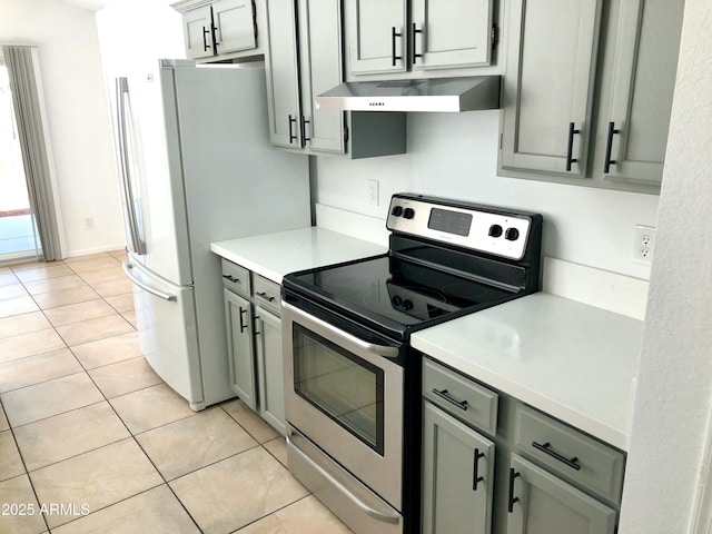 kitchen featuring light tile patterned flooring, white refrigerator, stainless steel electric stove, and gray cabinets