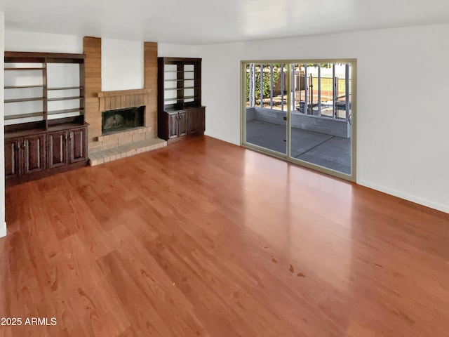 unfurnished living room with a fireplace and light wood-type flooring