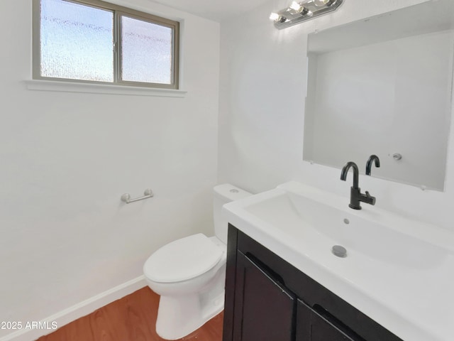 bathroom with hardwood / wood-style floors, vanity, and toilet